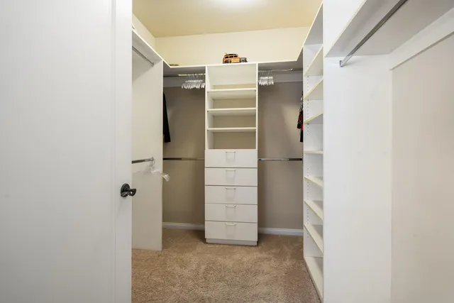 a view of walk in closet with clothes