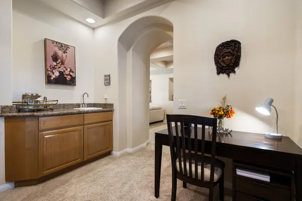 a kitchen with stainless steel appliances granite countertop a dining table chairs and a refrigerator