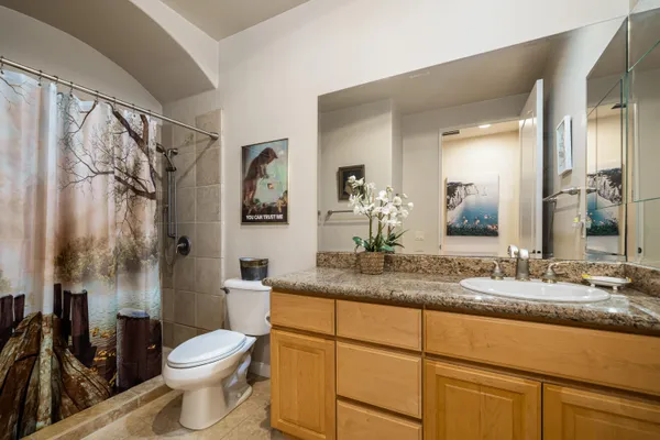 a bathroom with a granite countertop sink toilet and a mirror