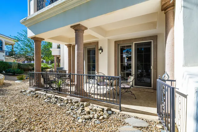 a view of a patio with table and chairs and wooden fence