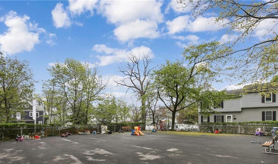 60 Locust Avenue, Unit 610 New Rochelle, NY 10801 - Photo 21 of 22 a city street lined with buildings and trees