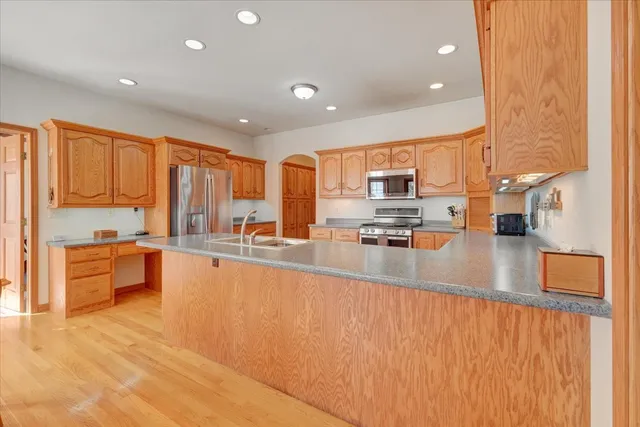 a large kitchen with stainless steel appliances lots of counter top space and a refrigerator