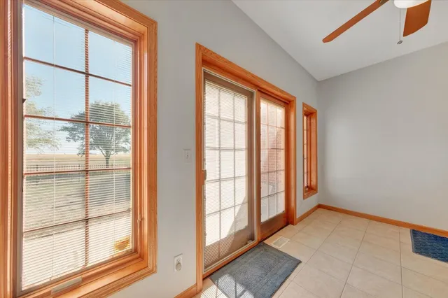 a view of an empty room with wooden floor and windows