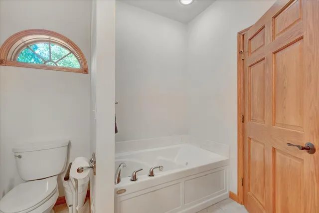 a bathroom with a bathtub toilet and window