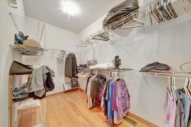 a view of walk in closet with clothes and shoes