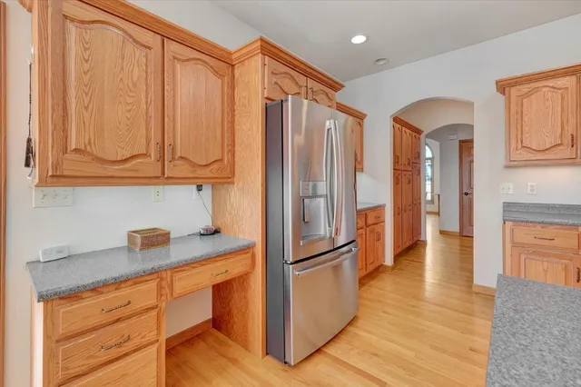 a kitchen with stainless steel appliances granite countertop a refrigerator and a stove top oven