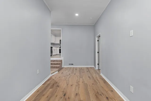 a view of empty room with wooden floor