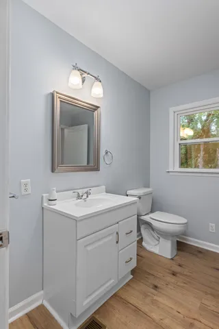 a bathroom with a toilet a sink a vanity and mirror