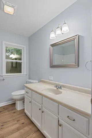a bathroom with a toilet a sink and mirror