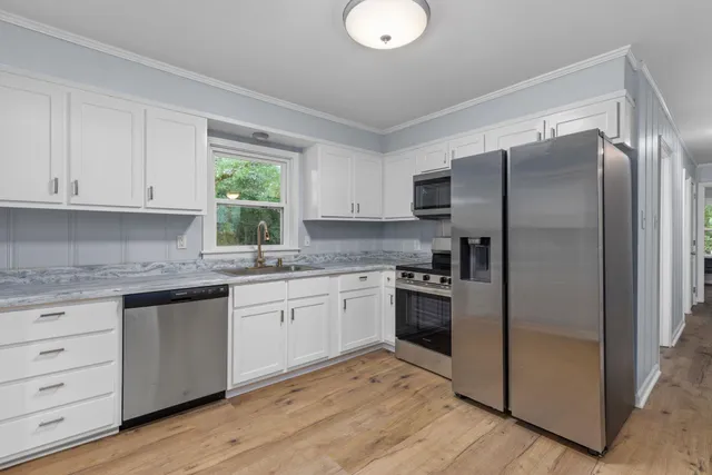 a kitchen with a refrigerator sink and cabinets