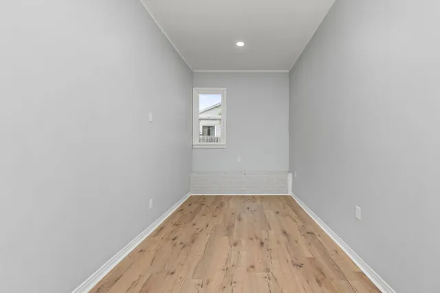 a view of empty room with wooden floor
