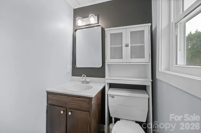 a bathroom with a toilet sink and mirror