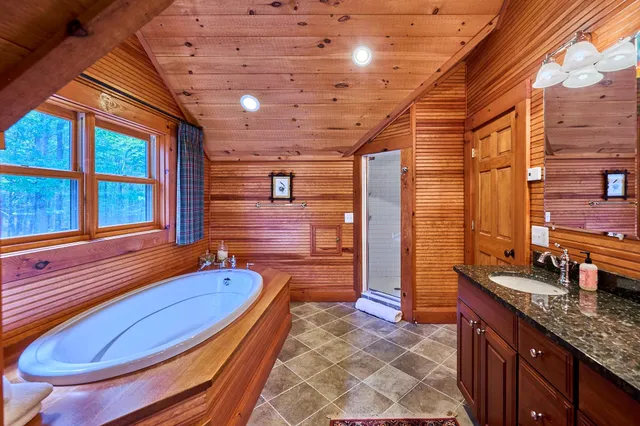 a bathroom with a granite countertop sink and a large mirror