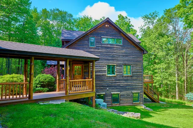 a view of a house with a small yard plants and large tree