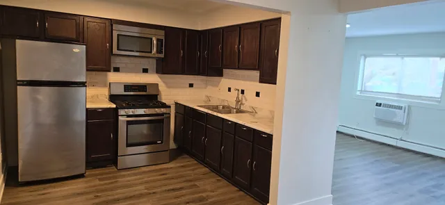 a kitchen with granite countertop a refrigerator stove and microwave