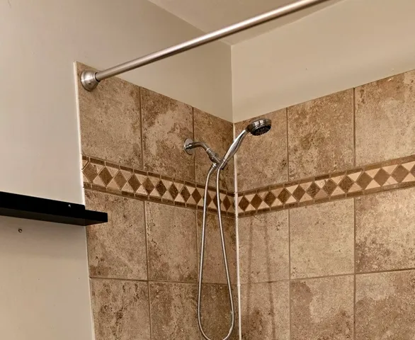 a bathroom with a shower and a shower head