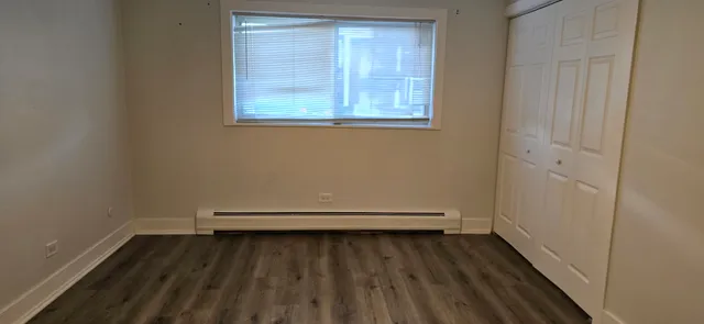 a view of a room with wooden floor and a window