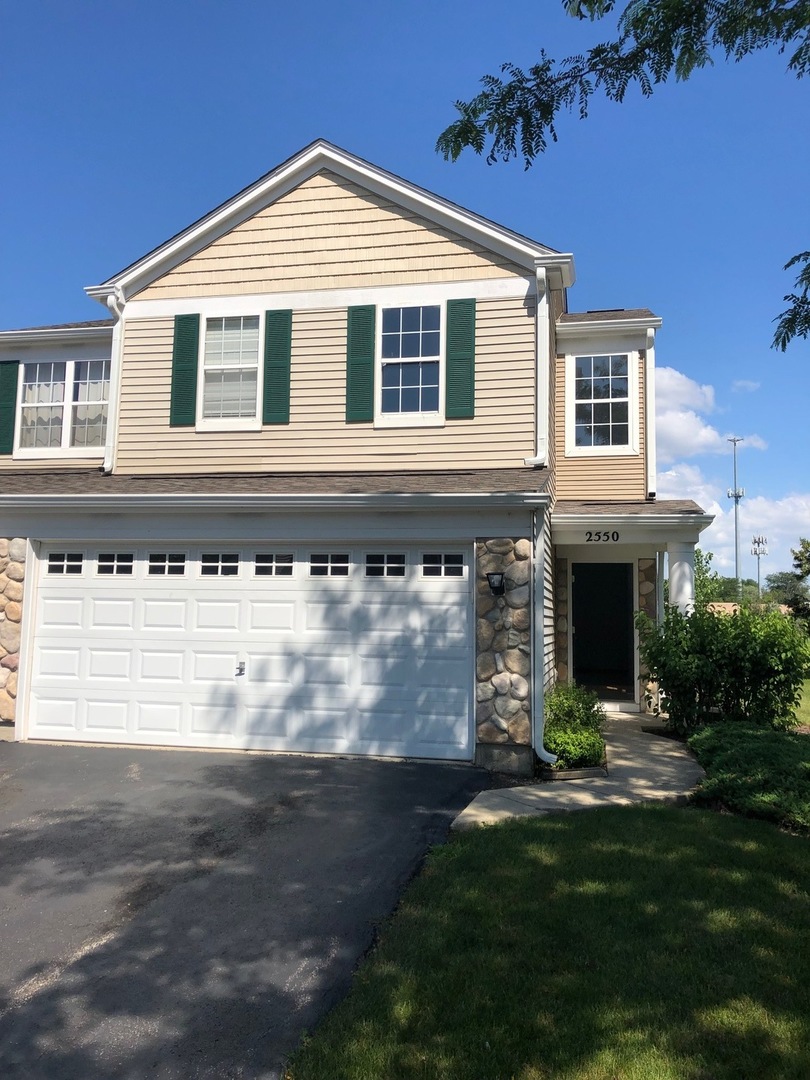 a front view of a house with a garden and garage