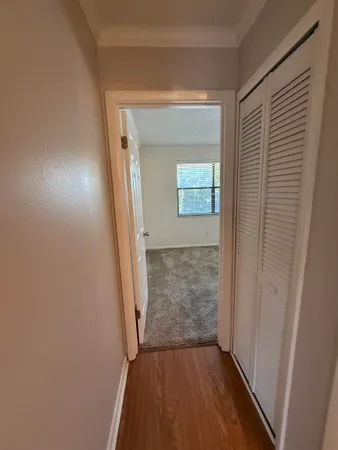 a view of a hallway with wooden floor and a living room