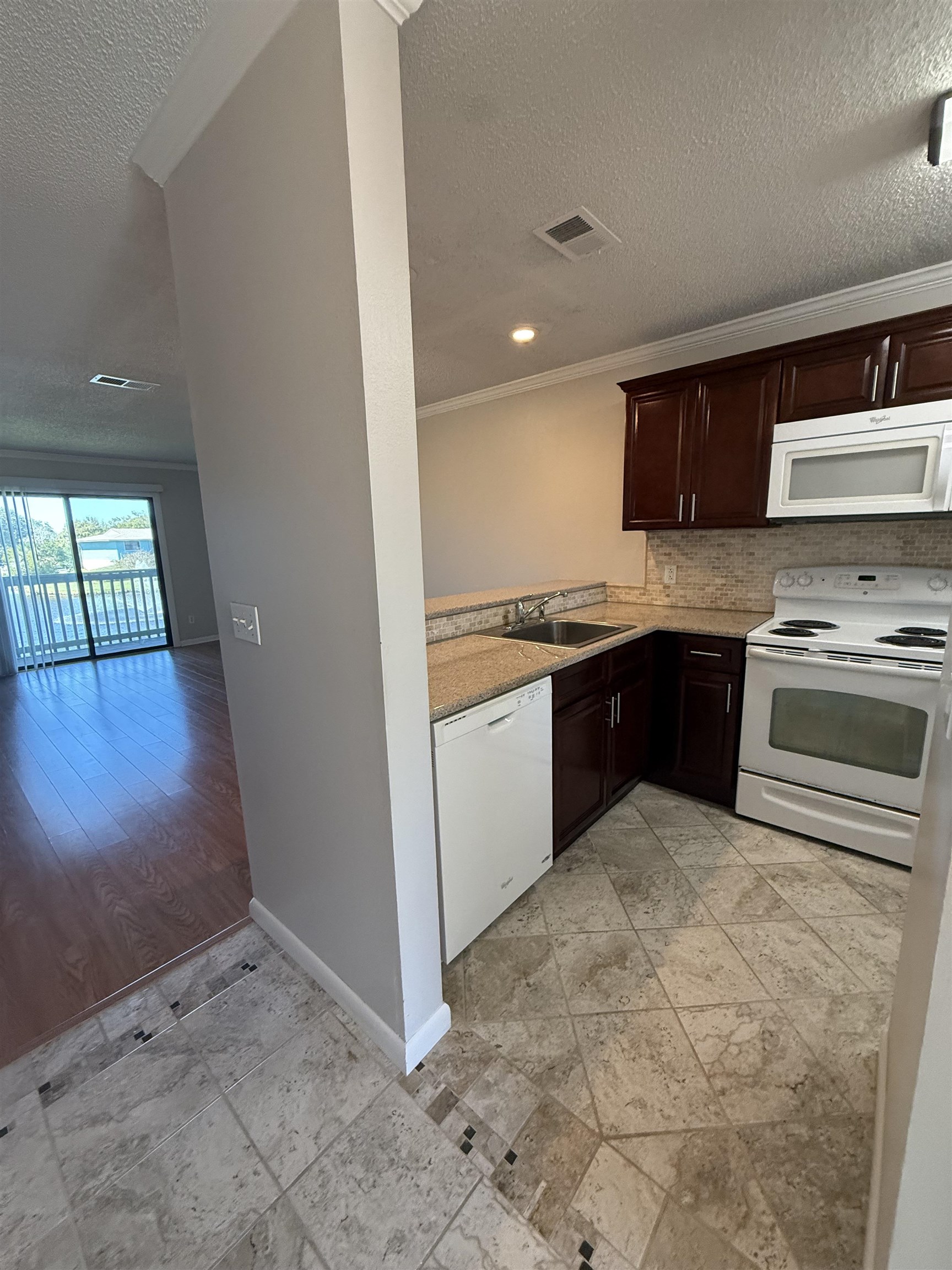 650 West Pope Road, Unit 225 St. Augustine, FL 32080 - Photo 3 of 21 a kitchen with stainless steel appliances granite countertop a stove a sink and a refrigerator