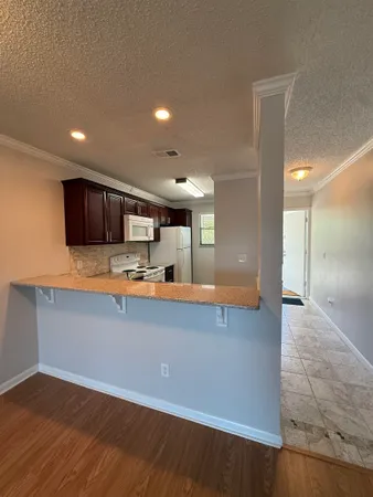 a large kitchen with stainless steel appliances a large counter top a stove and a refrigerator