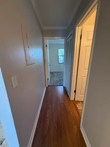 a view of a hallway with wooden floor and stairs