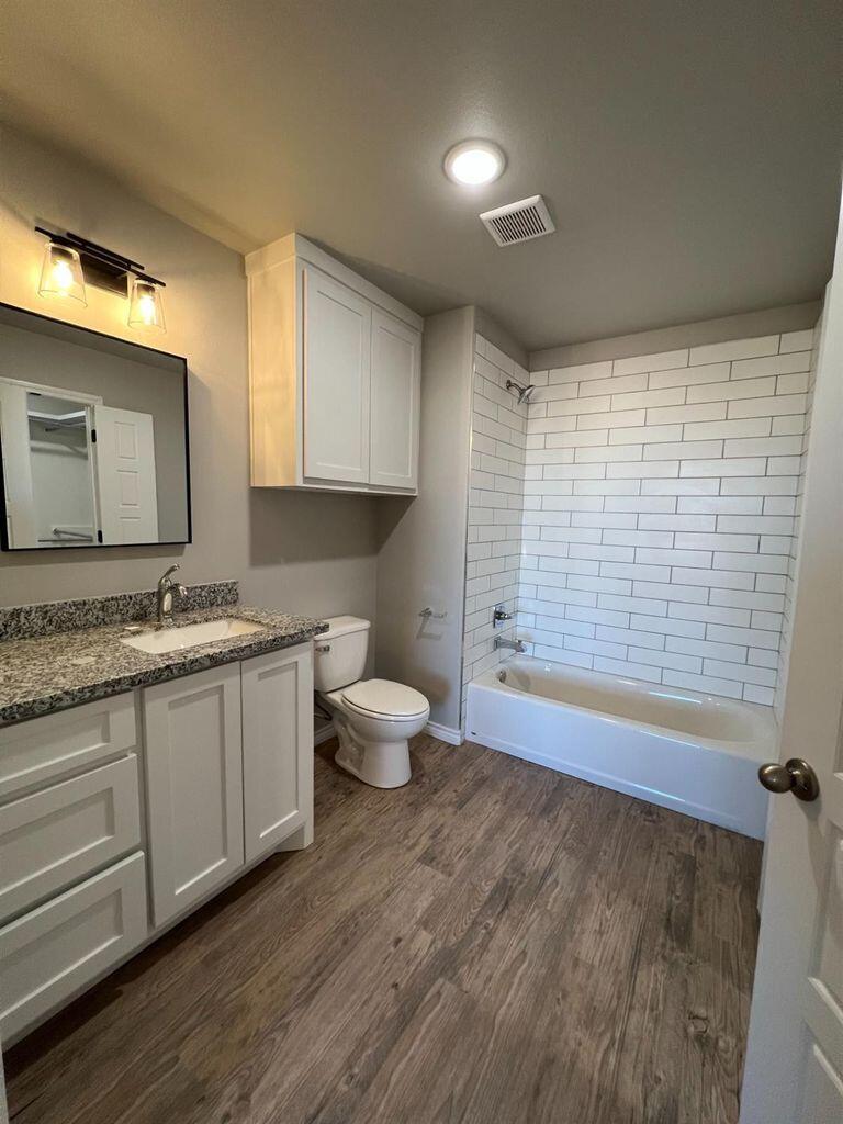 1407 17th Street, Unit A Shallowater, TX 79363 - Photo 12 of 18 a bathroom with a granite countertop sink and a large mirror