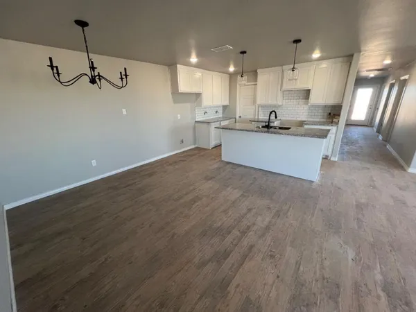 a view of a kitchen with a sink and wooden floor