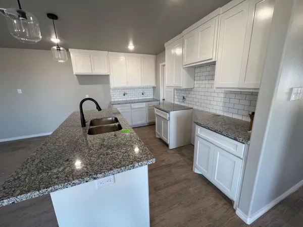 a kitchen with stainless steel appliances granite countertop a sink stove and cabinets