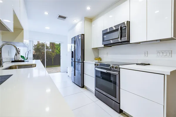 a kitchen with stainless steel appliances a stove microwave and sink