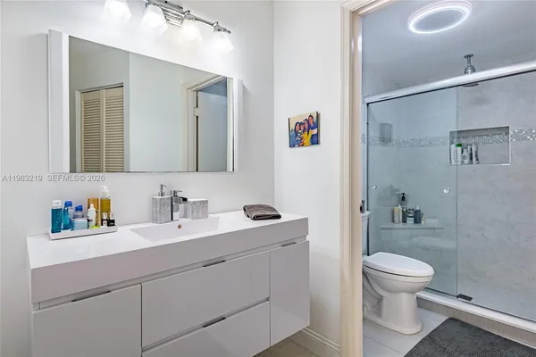 a bathroom with a toilet sink a mirror and shower
