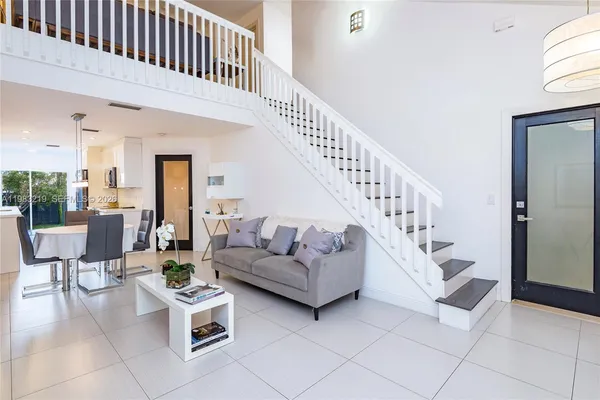 a living room with furniture and stairs