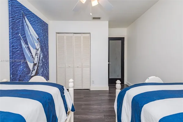 a bedroom with a bed and a lamp with wooden floor