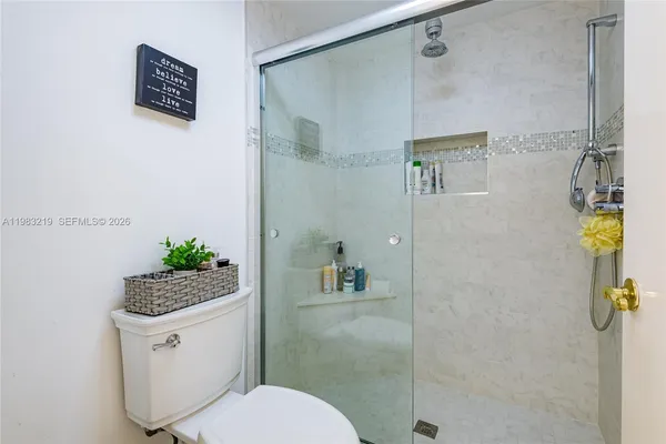a bathroom with a shower a toilet and a sink