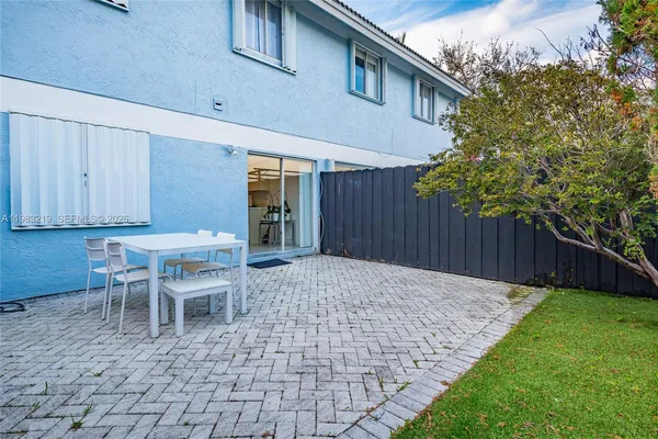 a backyard of a house with table and chairs