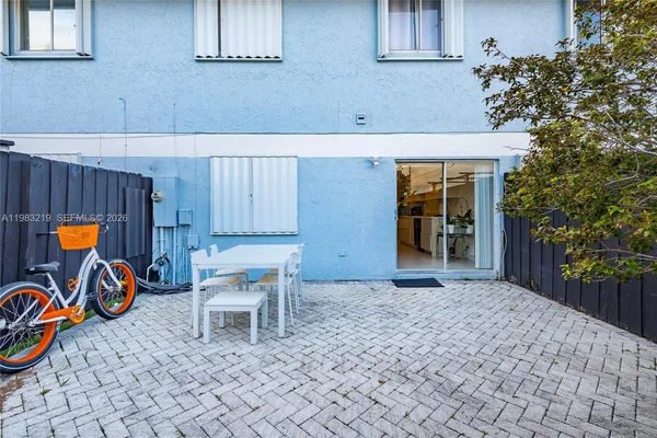 a view of a chairs and table in the back yard of the house