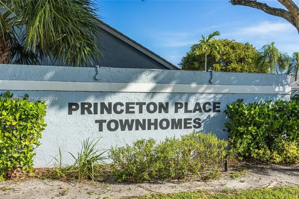a view of sign board with potted plants
