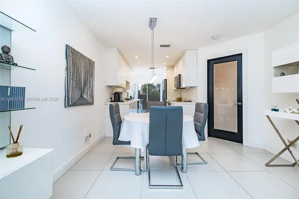 a dining room with furniture and a chandelier fan