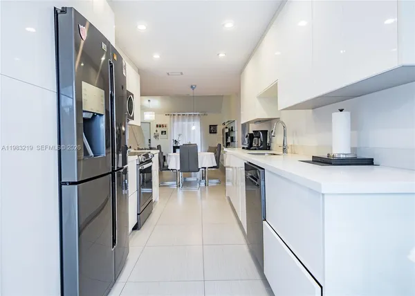 a kitchen with stainless steel appliances a refrigerator and a stove top oven