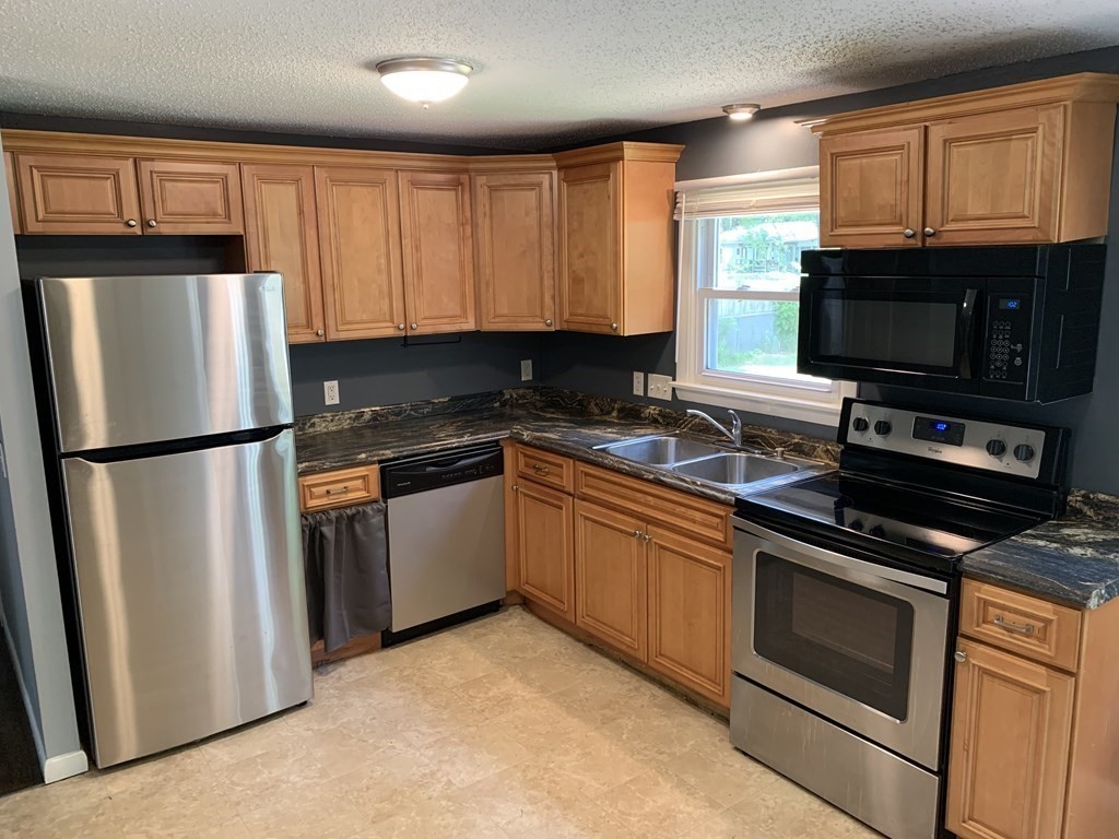 34 Portulaca Drive Springfield, MA 01129 - Photo 6 of 20 a kitchen with granite countertop a refrigerator stove and microwave