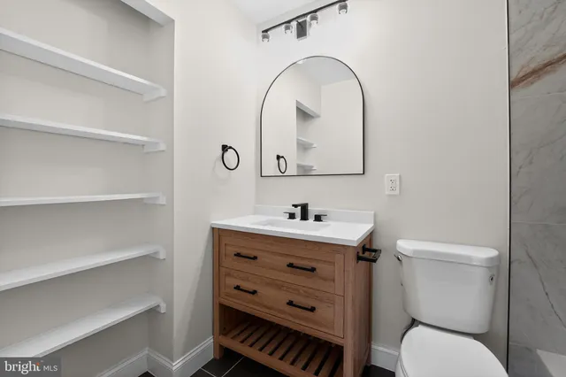 a bathroom with a toilet a sink and mirror