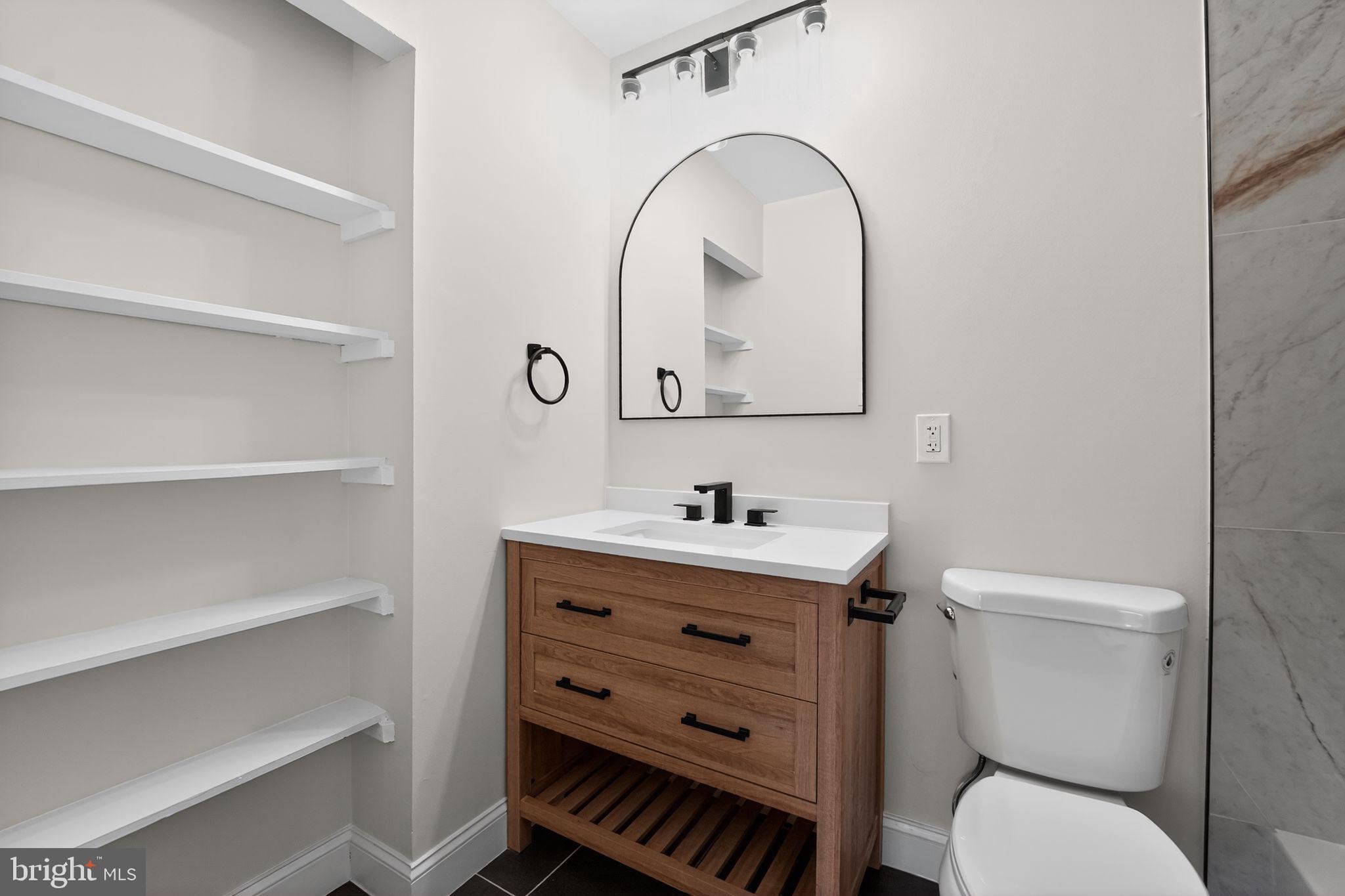 7344 Park Heights Avenue Baltimore, MD 21208 - Photo 17 of 33 a bathroom with a toilet a sink and mirror