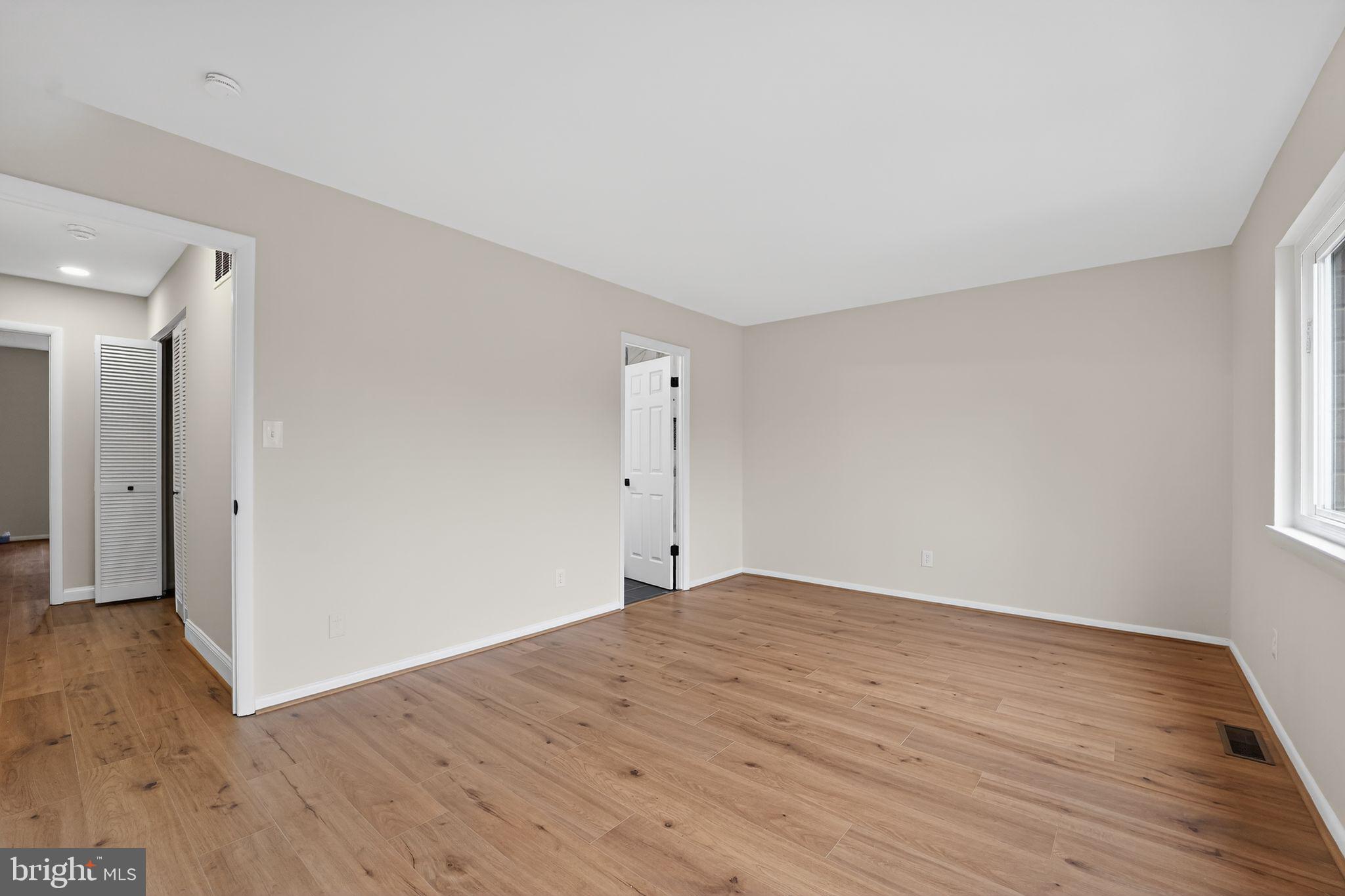 7344 Park Heights Avenue Baltimore, MD 21208 - Photo 26 of 33 a view of an empty room with wooden floor and a window