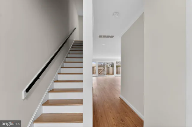 a view of staircase with wooden floor and white walls