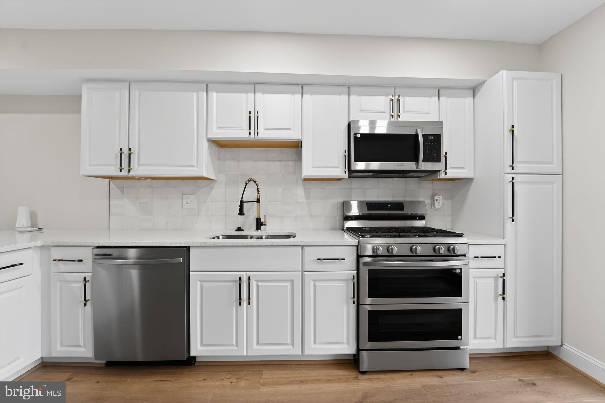 7344 Park Heights Avenue Baltimore, MD 21208 - Photo 3 of 33 a kitchen with white cabinets and stainless steel appliances