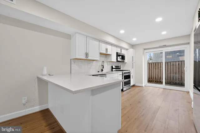 a kitchen with a sink a stove cabinets and a refrigerator