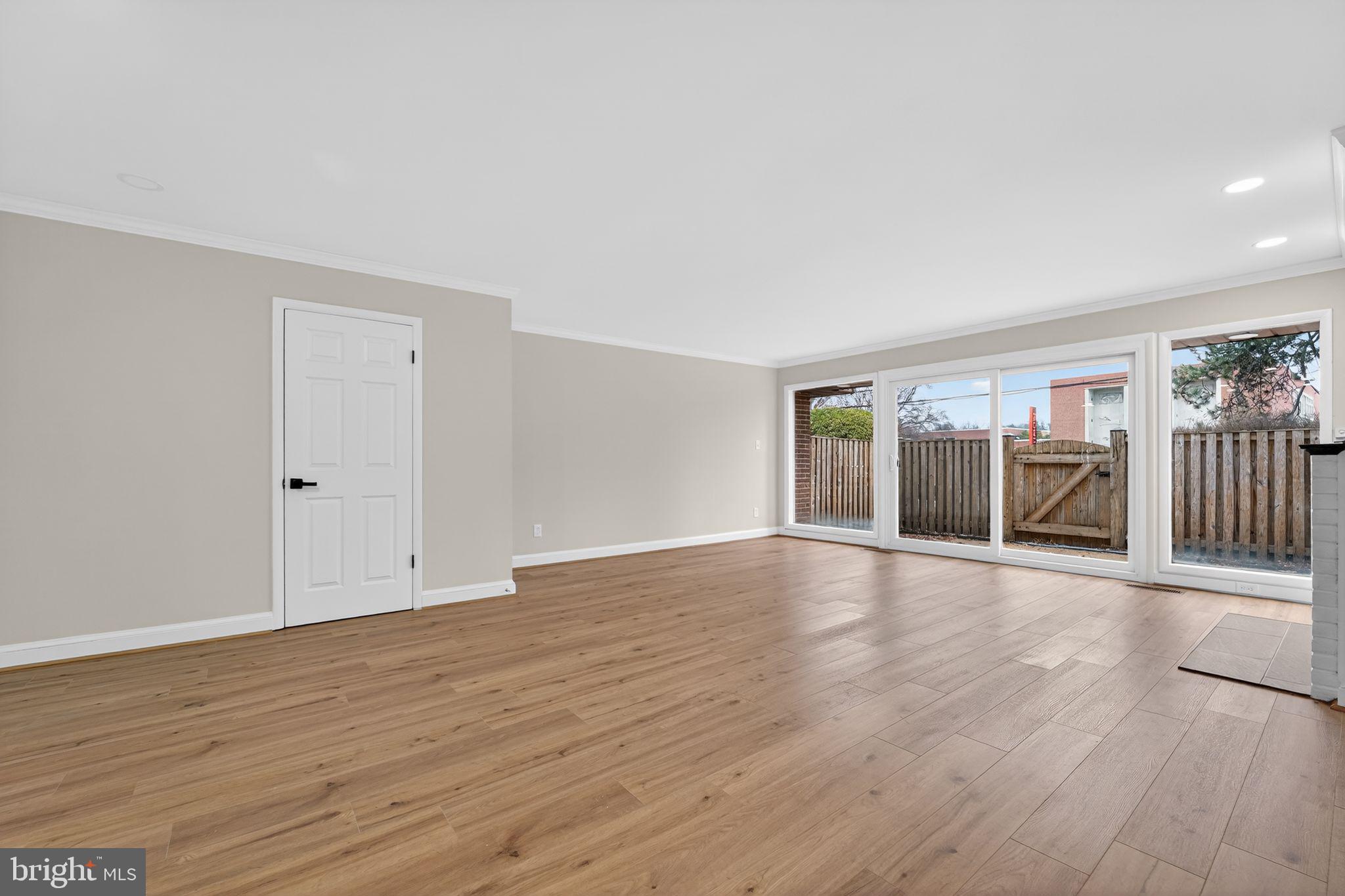 7344 Park Heights Avenue Baltimore, MD 21208 - Photo 6 of 33 a view of an empty room with wooden floor and a window