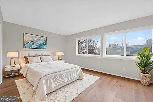 a bedroom with a large bed and a potted plant