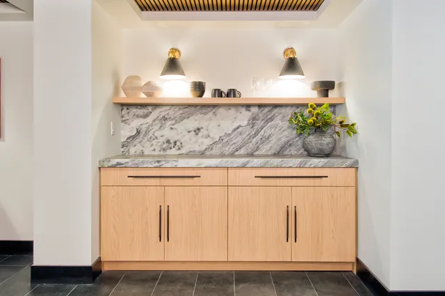 a kitchen with stainless steel appliances granite countertop a stove a refrigerator a microwave a sink and white cabinets with wooden floors