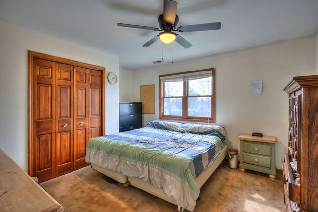a bedroom with a bed a window and a chandelier